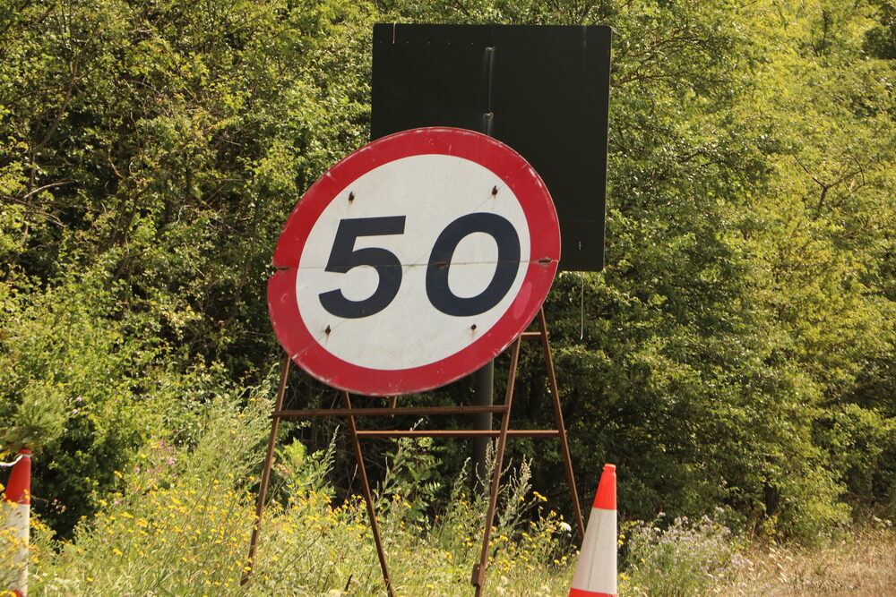 A temporary 50mph speed limit sign at the roadside, the setting for proposed 50mph national limits