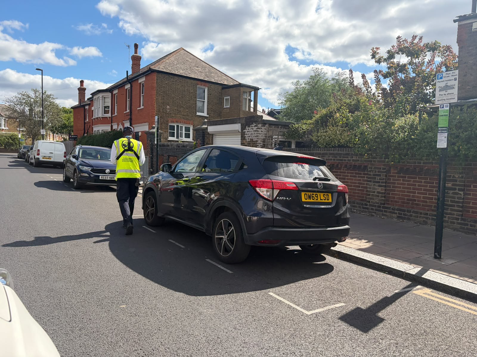 An enforcement officer checking a car -- the AA refused a breakdown over unpaid tax
