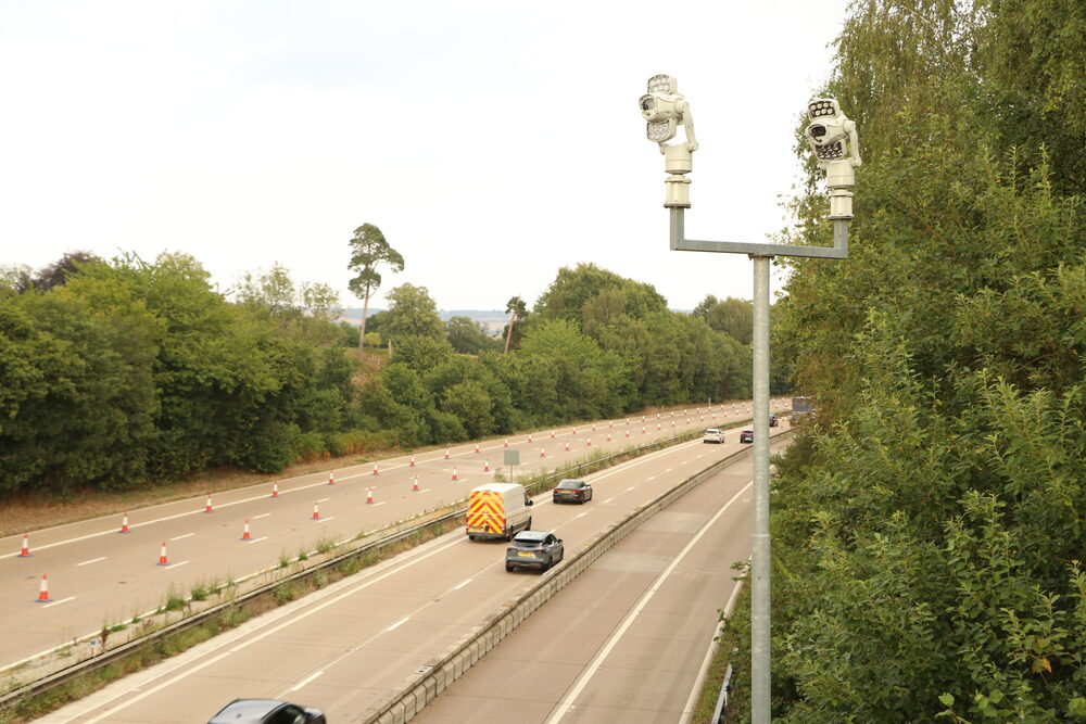 Two camera units mounted on a single roadside post, the style of AI cameras that catch phone and seatbelt offences