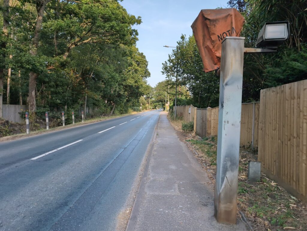 A quiet stretch of road with an out-of-service camera -- limits apply even with no repeater signs