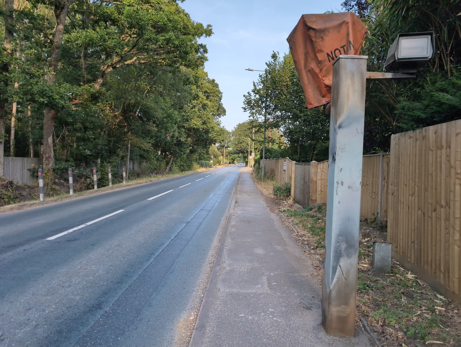A quiet stretch of road with an out-of-service camera -- limits apply even with no repeater signs