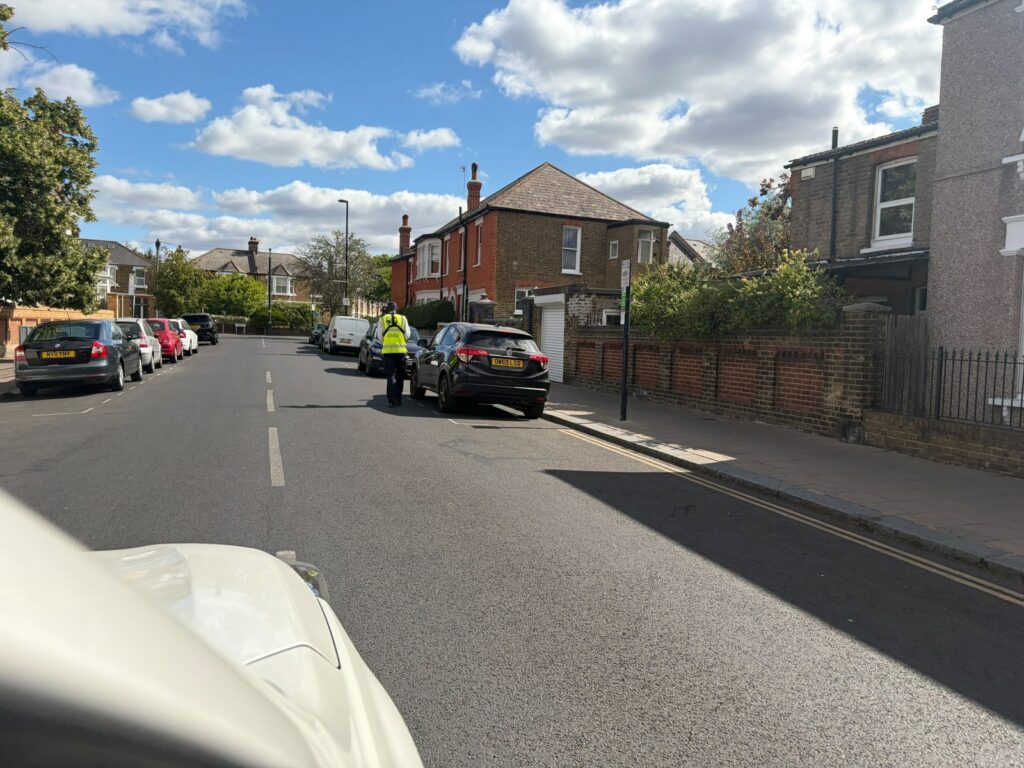 A civil enforcement officer on a residential street -- the LTN fines machine at work