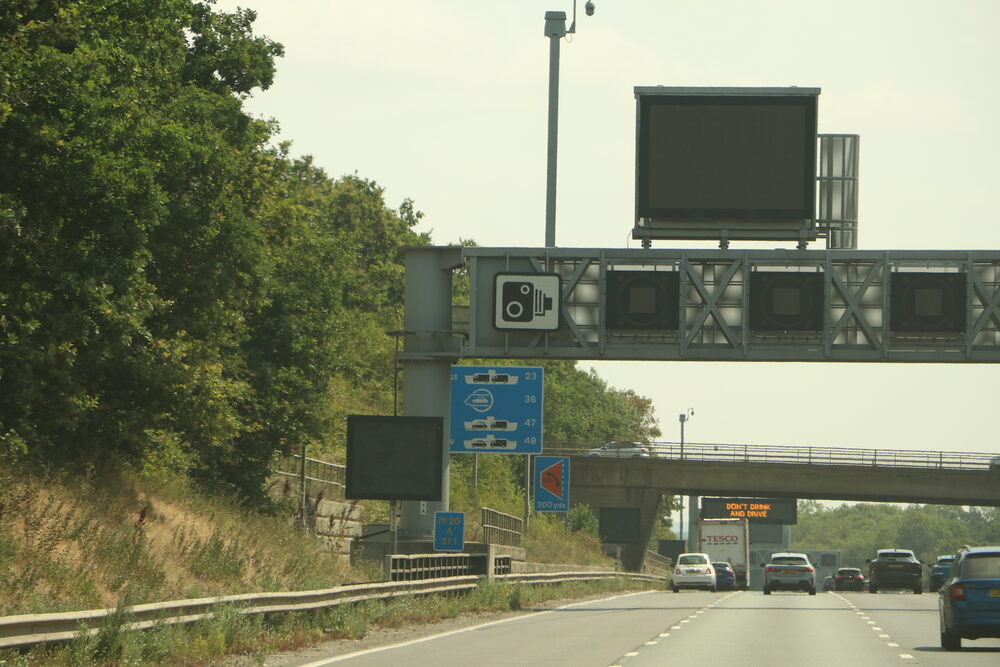 Traffic passing under motorway gantries — every mile could be taxed under pay-per-mile plans