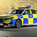 A marked police car with full livery and light bar — officers can stop any driver without giving a reason